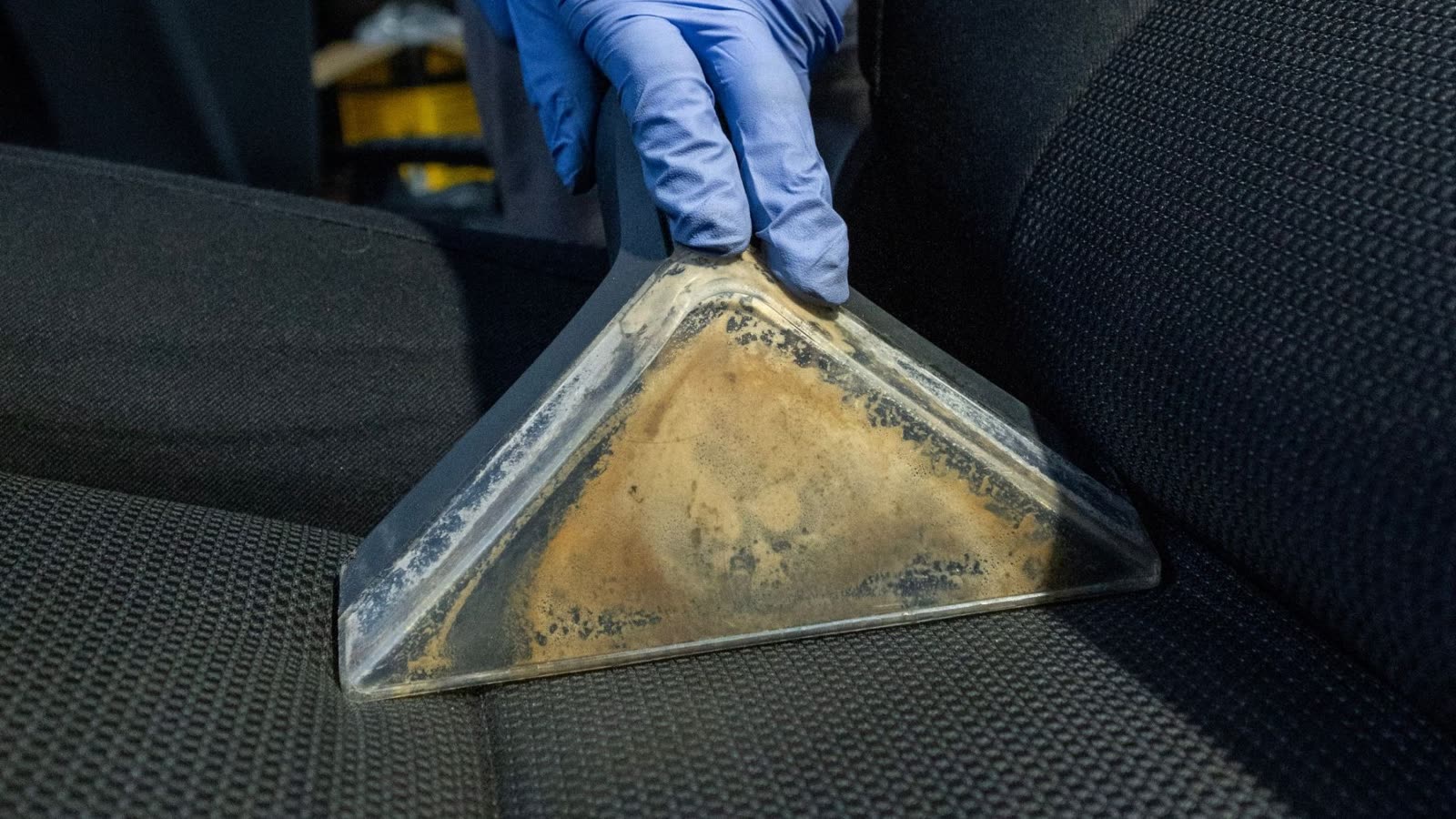 A professional fabric seat cleaning, extracting dirt out of a fabric seat by ALPHASHINE car detailing.