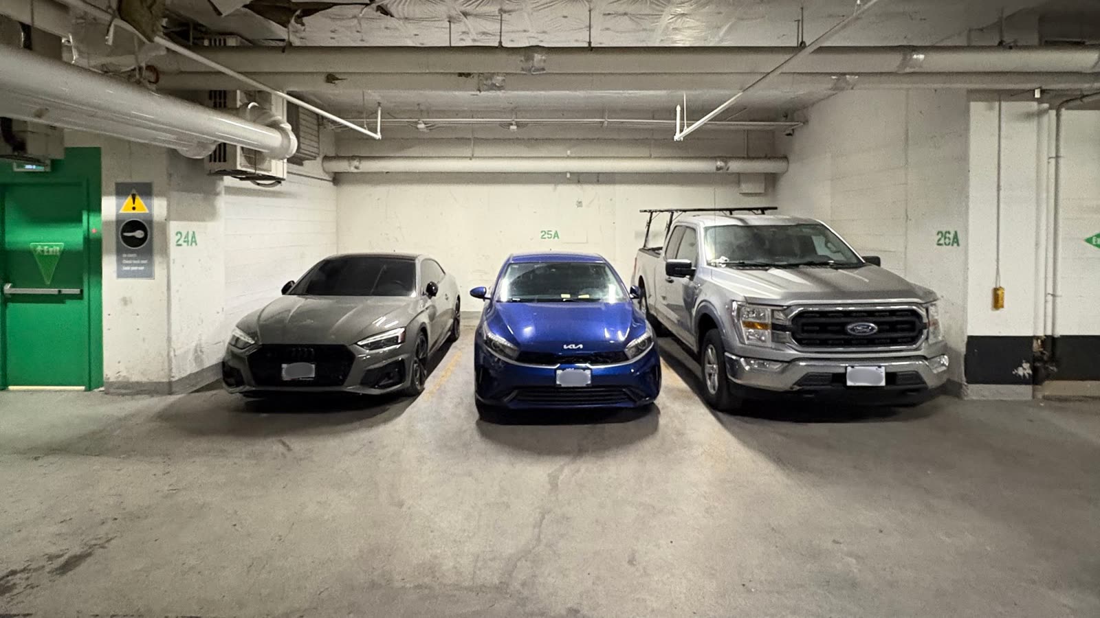 A row of cars parked in Downtown Toronto parking garage. 