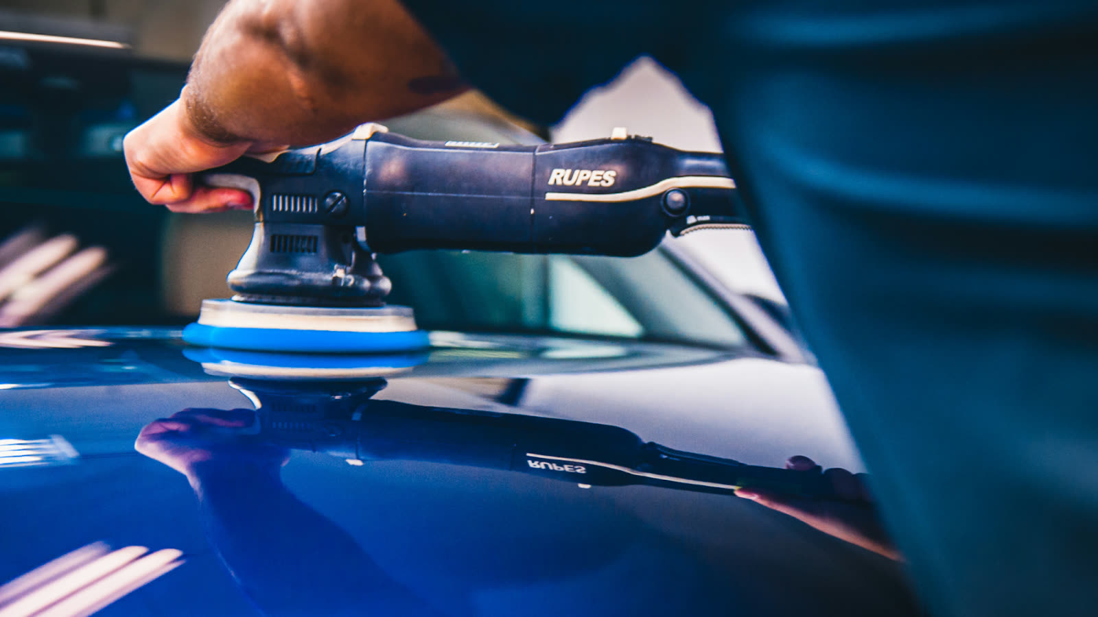 Close up of machine polishing during car paint detailing, highlighting expert car detailing with paint correction to remove swirl marks and enhance gloss.