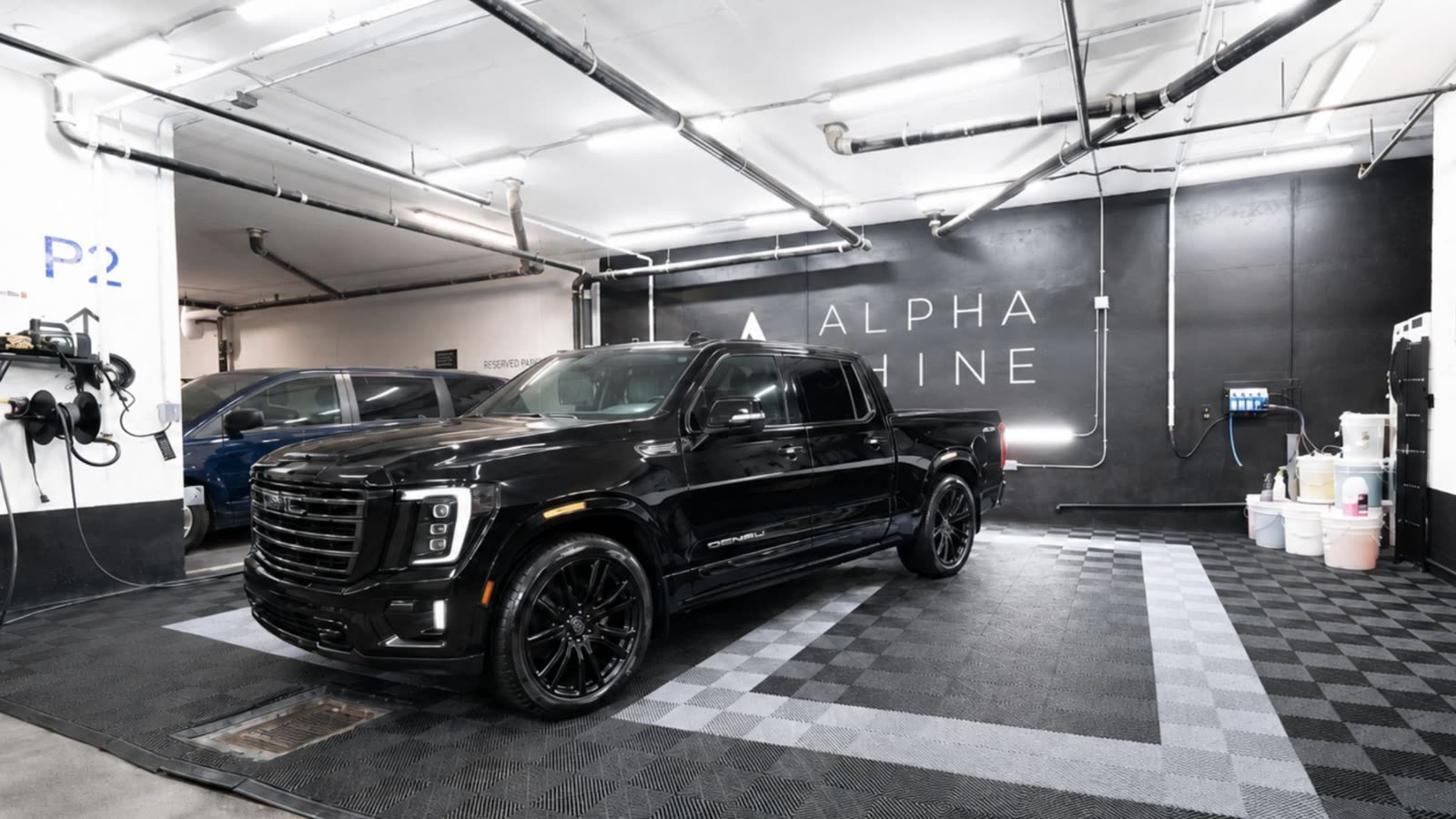 A black pickup truck parked in ALPHASHINE's King West facility after a pick up truck detail