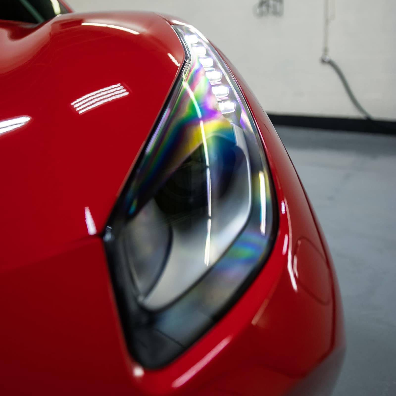 Clear headlights following professional restoration service on a red ferrari