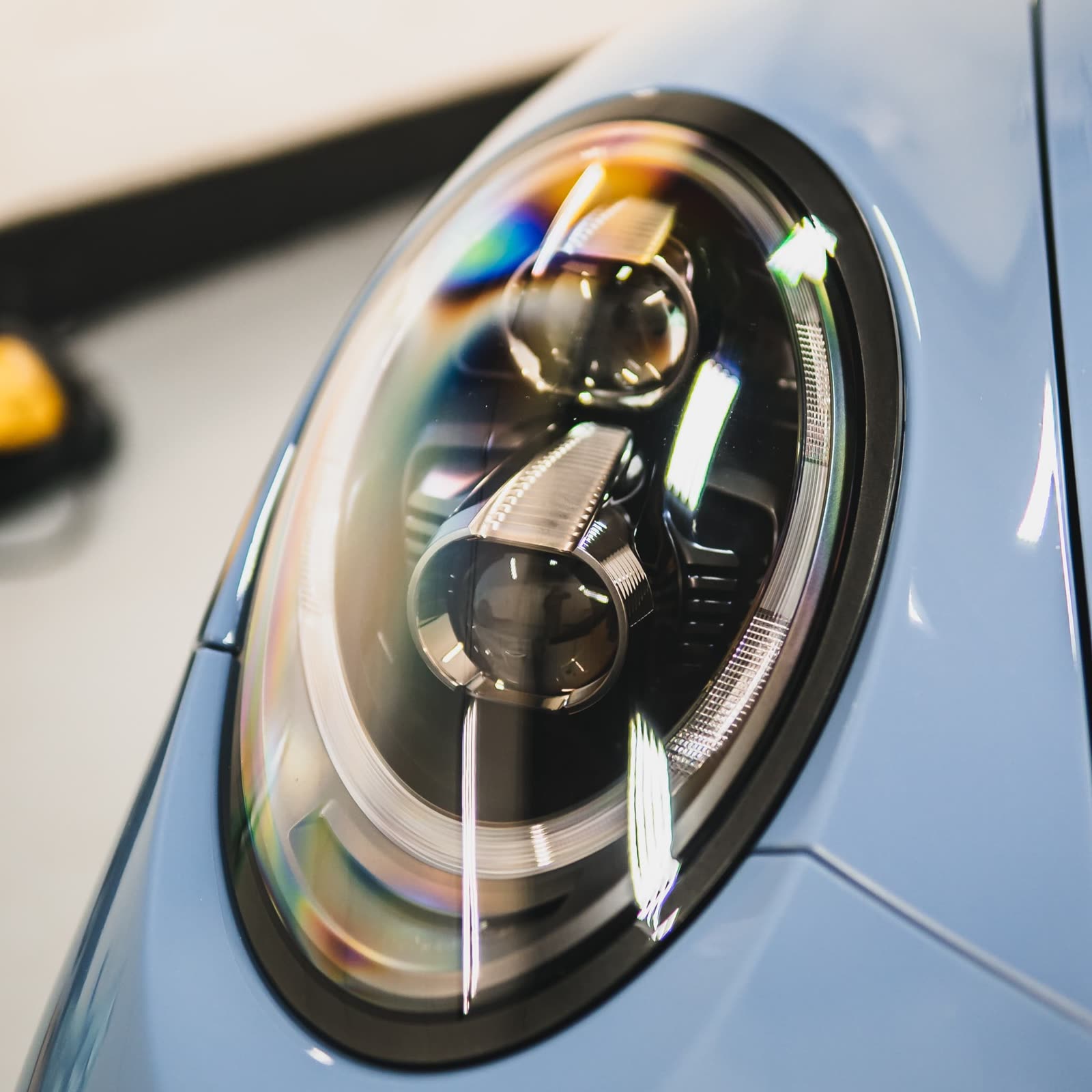 Clear headlights following professional restoration service on a blue porsche