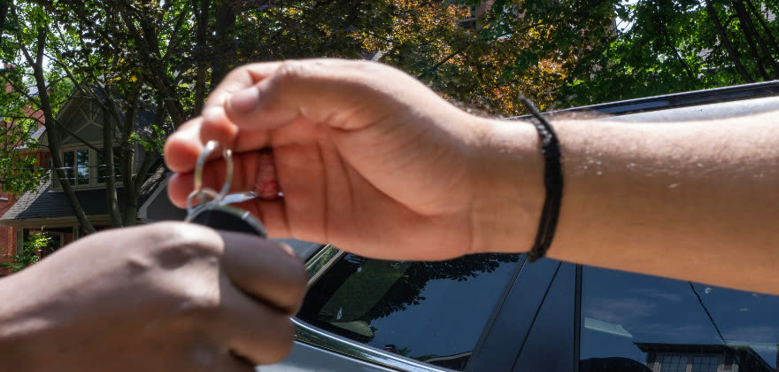 Customer handing over car keys for valet service from ALPHASHINE Car Detailing in CabbageTown, Toronto.